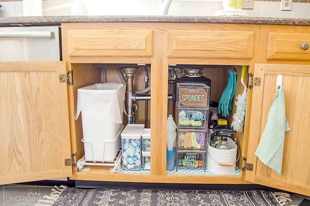 چیدمان کابینت زیر سینک ظرفشویی با نصب میله‌ها و آویزها