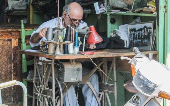 قفسه‌های پشت سر آقای خیاط که اندازه تمام تاریخ اصالت دارد