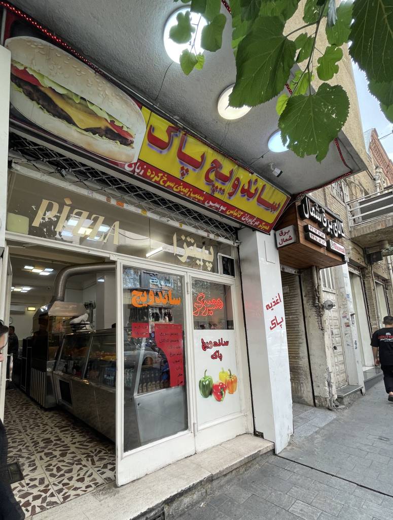ویترین و تابلو یک مغازه در لاله‌زار که انتهای دلتنگی است